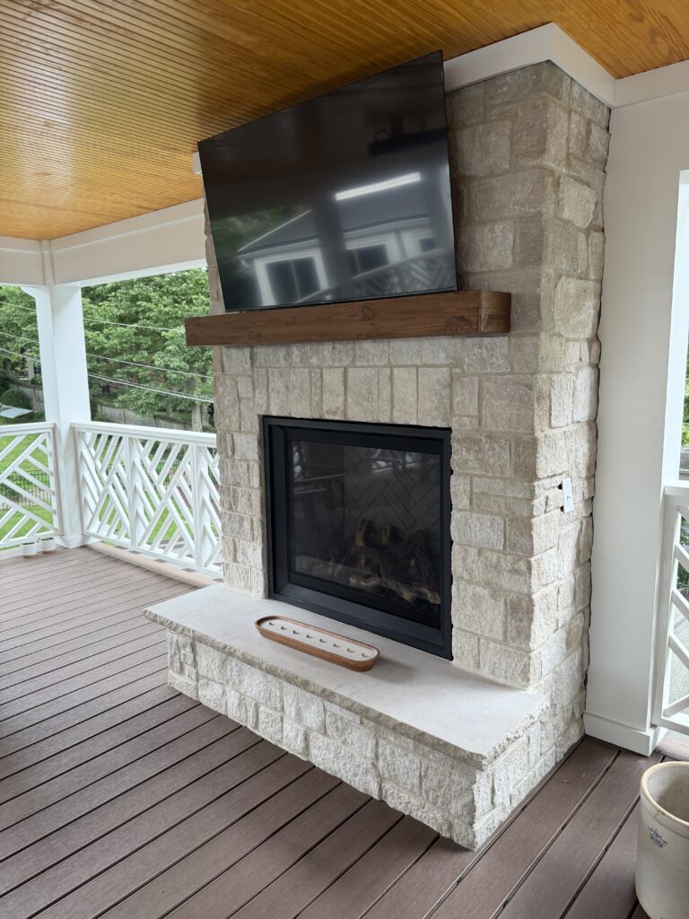 stone fireplace with mantle and TV